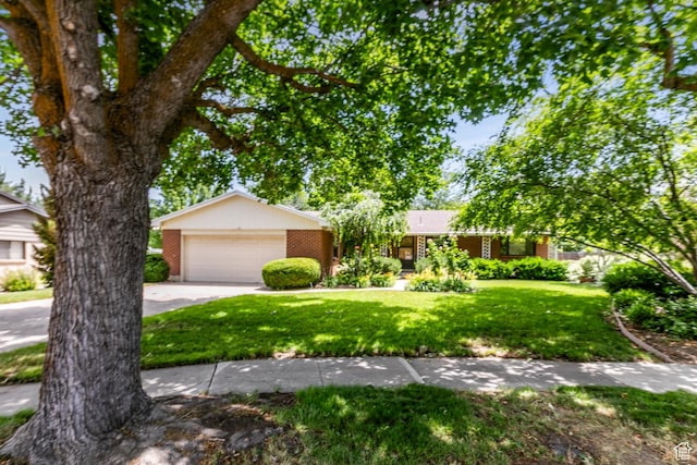 5681 S Calann Dr E, Holladay, UT 84121 - view of front of home featuring brick siding, a front yard, a garage, and concrete driveway