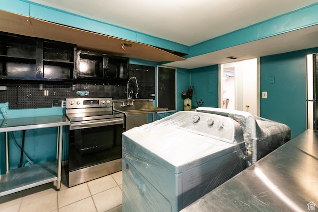 5681 S Calann Dr E, Holladay, UT 84121 - kitchen featuring electric stove, stainless steel counters, washer / clothes dryer, and tile patterned flooring