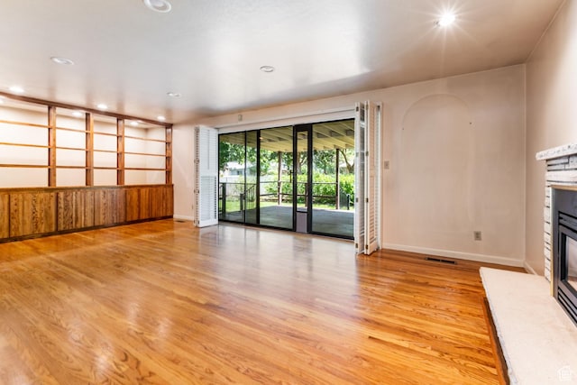 5681 S Calann Dr E, Holladay, UT 84121 - unfurnished living room with a glass covered fireplace, light wood-style flooring, and recessed lighting