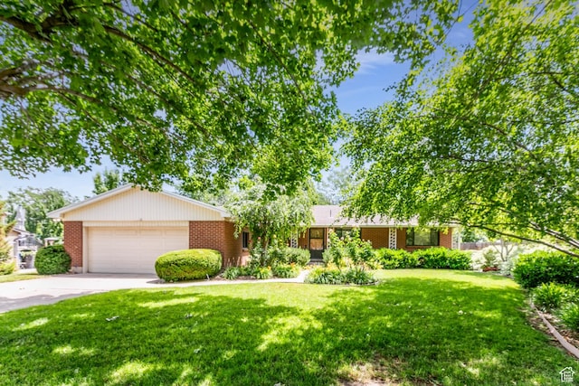 5681 S Calann Dr E, Holladay, UT 84121 - ranch-style house featuring brick siding, concrete driveway, a front yard, and an attached garage