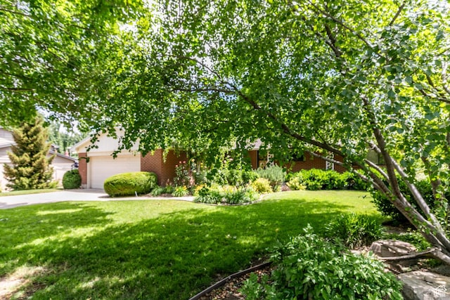 5681 S Calann Dr E, Holladay, UT 84121 - obstructed view of property with a front yard, concrete driveway, brick siding, and a garage