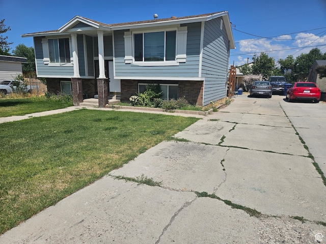 3243 S Fairlane St, Magna, UT 84044 - bi-level home with a front lawn, brick siding, and concrete driveway