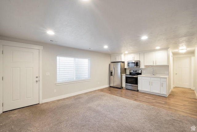 142 W Hackberry Rd, Vineyard, UT 84059 - kitchen with stainless steel appliances, light colored carpet, white cabinetry, recessed lighting, and light countertops