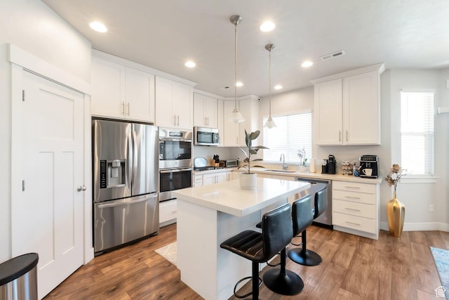 142 W Hackberry Rd, Vineyard, UT 84059 - kitchen with stainless steel appliances, a kitchen bar, white cabinetry, wood finished floors, and a kitchen island