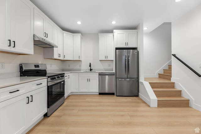 3839 W Saddler Dr, West Jordan, UT 84088 - kitchen with stainless steel appliances, under cabinet range hood, white cabinetry, recessed lighting, and light countertops