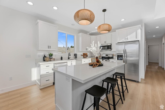 3839 W Saddler Dr, West Jordan, UT 84088 - kitchen featuring stainless steel appliances, a kitchen bar, light wood-style floors, recessed lighting, and white cabinets