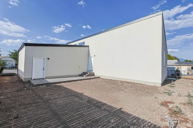 3839 W Saddler Dr, West Jordan, UT 84088 - rear view of property featuring entry steps, stucco siding, and a patio