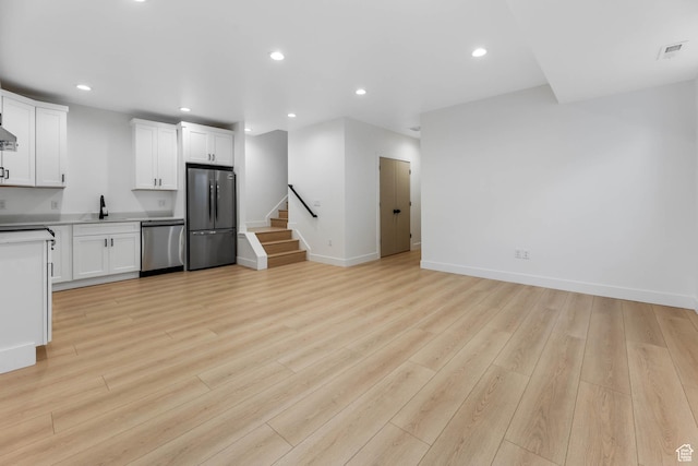3839 W Saddler Dr, West Jordan, UT 84088 - unfurnished living room with recessed lighting, stairway, and light wood-style flooring