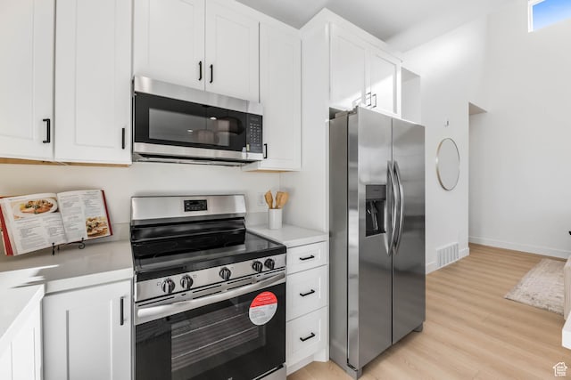 3839 W Saddler Dr, West Jordan, UT 84088 - kitchen with appliances with stainless steel finishes, light wood-style floors, light countertops, and white cabinets