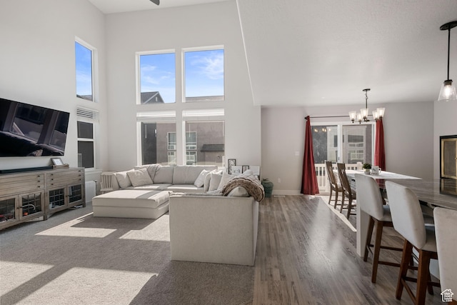 12333 S Pesky Ln, Herriman, UT 84096 - living room with a chandelier, plenty of natural light, a high ceiling, and wood finished floors