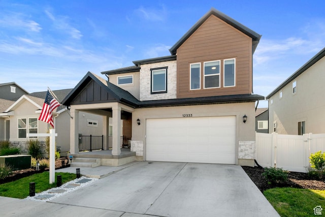 12333 S Pesky Ln, Herriman, UT 84096 - view of front of property with stone siding, concrete driveway, an attached garage, a porch, and board and batten siding