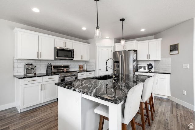 12333 S Pesky Ln, Herriman, UT 84096 - kitchen featuring stainless steel appliances, dark wood finished floors, a kitchen bar, tasteful backsplash, and recessed lighting