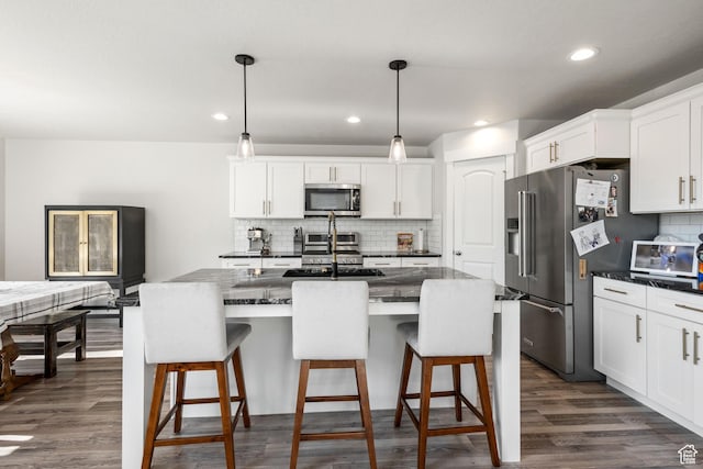 12333 S Pesky Ln, Herriman, UT 84096 - kitchen featuring stainless steel appliances, backsplash, white cabinets, a kitchen bar, and dark wood finished floors