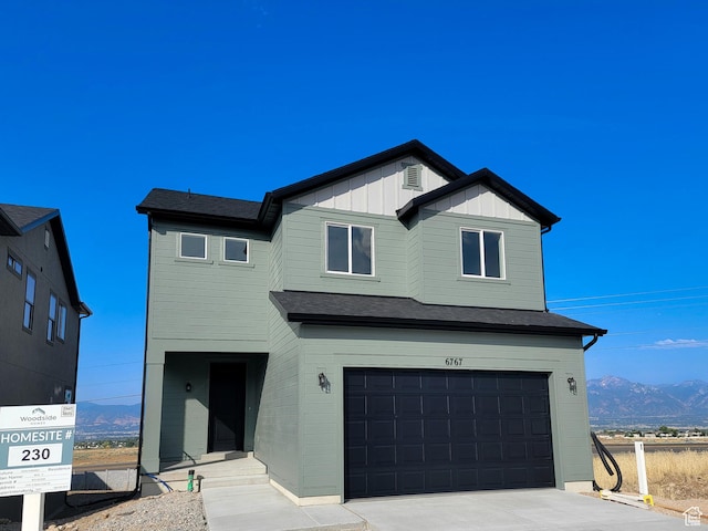 6767 S Glade Creek Dr Unit 230, West Jordan, UT 84081 - view of front of house featuring an attached garage, a mountain view, board and batten siding, and driveway