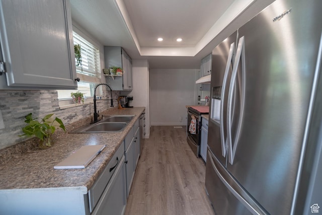 988 N Smith Dr, Price, UT 84501 - kitchen with appliances with stainless steel finishes, decorative backsplash, light wood-style flooring, a tray ceiling, and recessed lighting