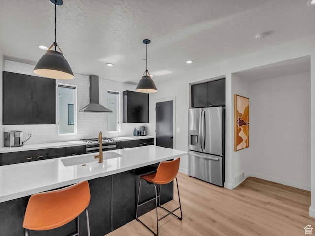 351 W 800 N # 9, Salt Lake City, UT 84103 - kitchen featuring stainless steel fridge, wall chimney range hood, dark cabinets, light countertops, and recessed lighting
