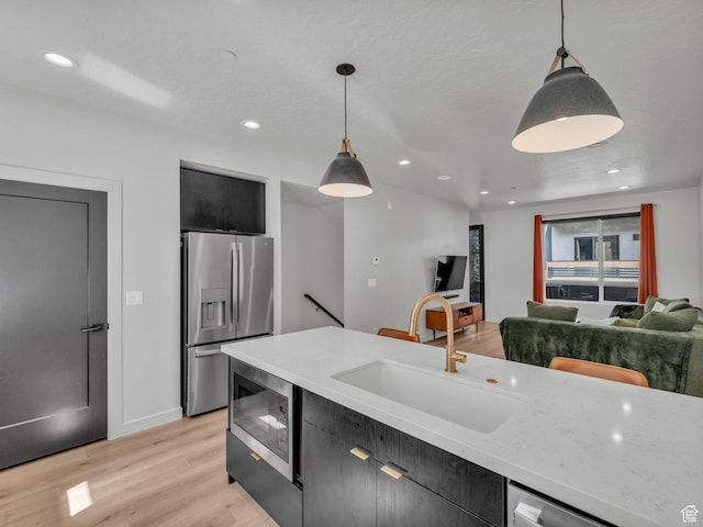 351 W 800 N # 9, Salt Lake City, UT 84103 - kitchen featuring stainless steel appliances, dark cabinetry, hanging light fixtures, light wood-style flooring, and recessed lighting