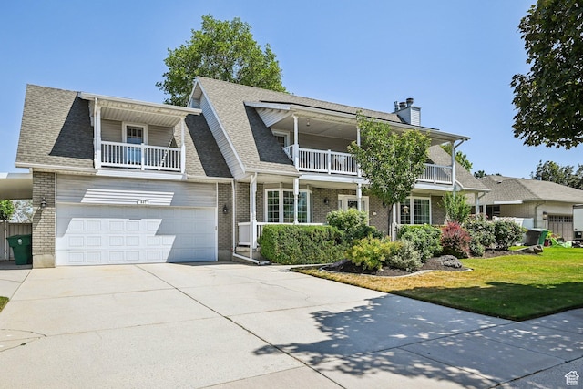 537 E Edindrew Cir, Murray, UT 84107 - view of front facade with a balcony, concrete driveway, brick siding, and an attached garage