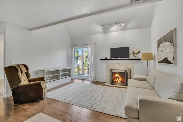 5327 S 560 E Unit F, Murray, UT 84107 - living room with lofted ceiling, wood finished floors, a premium fireplace, a textured ceiling, and rail lighting