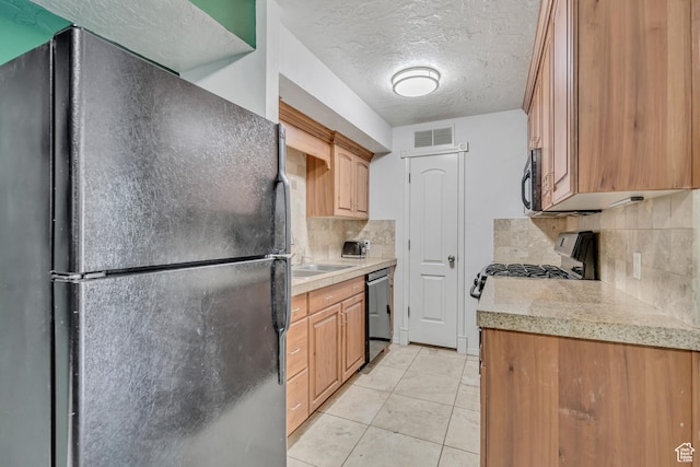 5327 S 560 E Unit F, Murray, UT 84107 - kitchen with freestanding refrigerator, dishwasher, backsplash, light countertops, and a textured ceiling