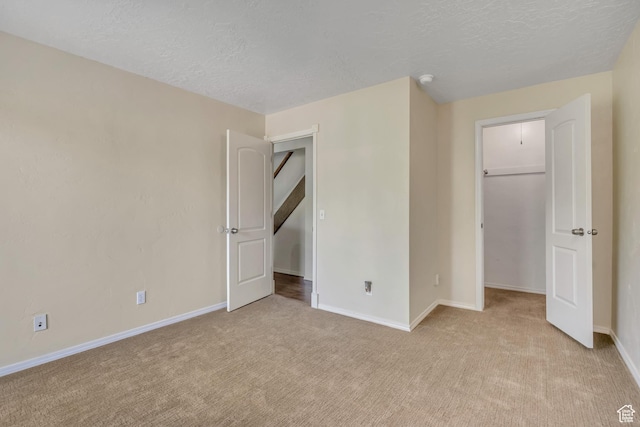 5327 S 560 E Unit F, Murray, UT 84107 - unfurnished bedroom featuring carpet, a walk in closet, a textured ceiling, and a closet