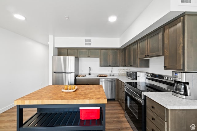 443 Kane Creek Blvd Unit 212, Moab, UT 84532 - kitchen with stainless steel appliances, dark brown cabinetry, dark wood-style flooring, wood counters, and recessed lighting