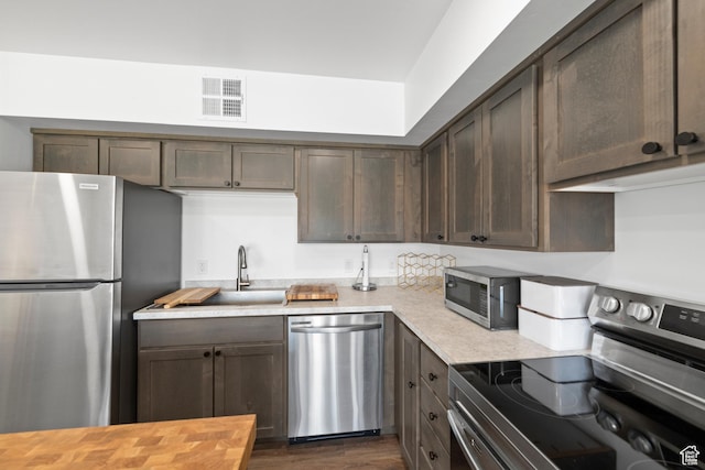 443 Kane Creek Blvd Unit 212, Moab, UT 84532 - kitchen with stainless steel appliances, dark brown cabinetry, dark wood finished floors, and butcher block counters