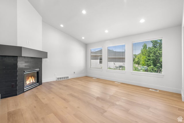 713 S 600 E, Layton, UT 84041 - unfurnished living room featuring light wood-style flooring, a multi sided fireplace, recessed lighting, and vaulted ceiling
