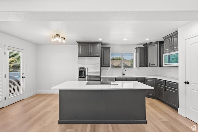 713 S 600 E, Layton, UT 84041 - kitchen with stainless steel fridge with ice dispenser, light wood finished floors, backsplash, light countertops, and recessed lighting