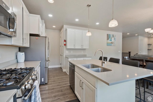 3359 N Redshoulder Dr, Layton, UT 84040 - kitchen with appliances with stainless steel finishes, a kitchen breakfast bar, light wood-type flooring, light countertops, and white cabinetry