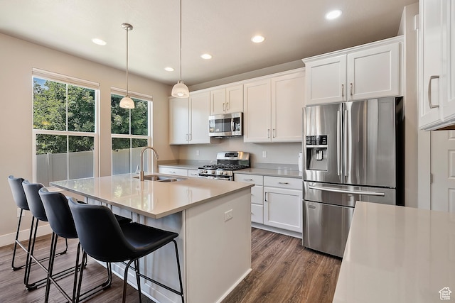 3359 N Redshoulder Dr, Layton, UT 84040 - kitchen featuring appliances with stainless steel finishes, dark wood-style floors, recessed lighting, a center island with sink, and white cabinets