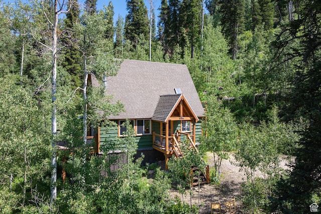 1519 Pine Needle Cir, Coalville, UT 84017 - view of front of house featuring roof with shingles, a wooded view, and a wooden deck