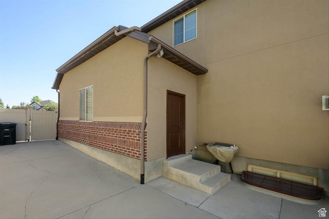 3371 W Waterbridge Cv Unit 417, South Jordan, UT 84095 - view of home's exterior featuring a patio area, stucco siding, and entry steps