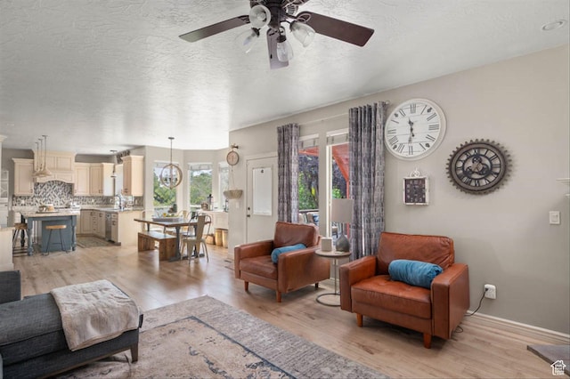 3371 W Waterbridge Cv Unit 417, South Jordan, UT 84095 - living room featuring a ceiling fan, light wood-type flooring, and a textured ceiling