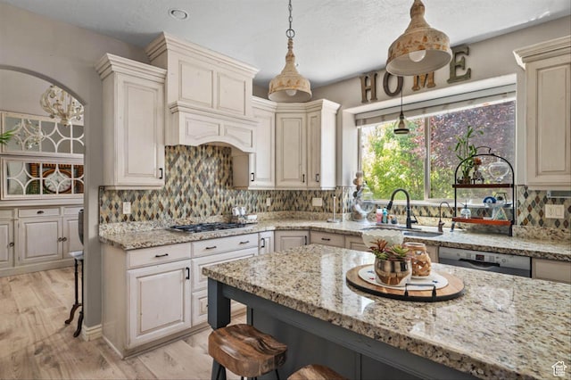 3371 W Waterbridge Cv Unit 417, South Jordan, UT 84095 - kitchen featuring a kitchen breakfast bar, light wood-style floors, light stone counters, and stainless steel appliances
