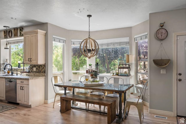 3371 W Waterbridge Cv Unit 417, South Jordan, UT 84095 - dining room featuring light wood-style floors, a chandelier, and a textured ceiling