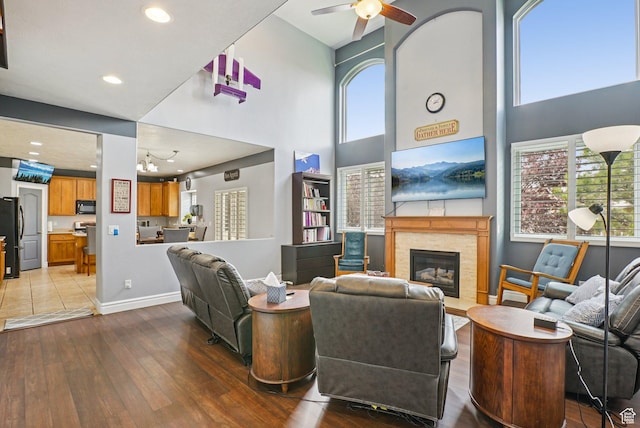 13626 S Bluewing Way, Riverton, UT 84096 - living room with hardwood / wood-style floors, a glass covered fireplace, a high ceiling, ceiling fan, and recessed lighting