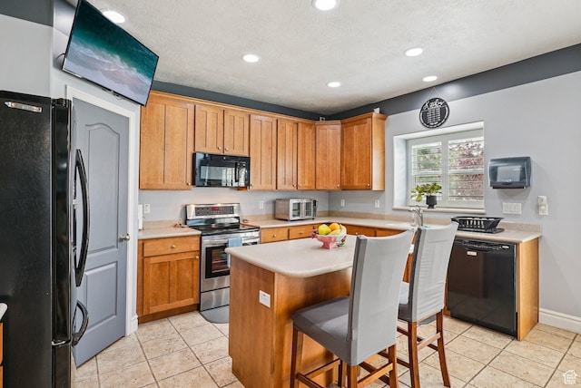 13626 S Bluewing Way, Riverton, UT 84096 - kitchen featuring black appliances, light countertops, recessed lighting, light tile patterned flooring, and a kitchen bar