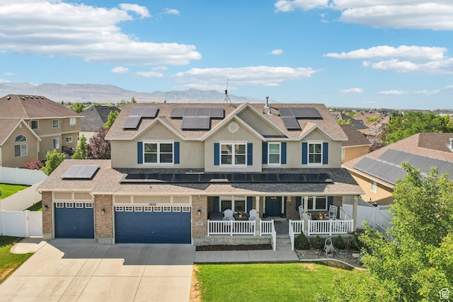 13626 S Bluewing Way, Riverton, UT 84096 - view of front facade with a porch, roof mounted solar panels, driveway, a mountain view, and a residential view