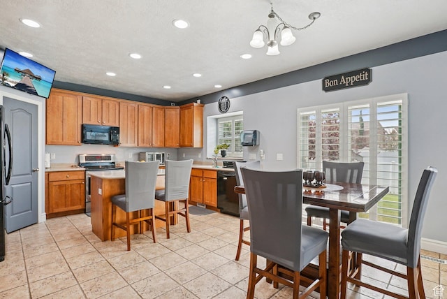 13626 S Bluewing Way, Riverton, UT 84096 - kitchen with black appliances, a chandelier, recessed lighting, a kitchen island, and brown cabinetry