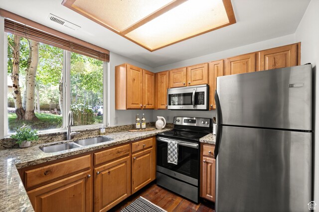 1600 W Pinebrook Blvd Unit F3, Park City, UT 84098 - kitchen featuring appliances with stainless steel finishes, light stone countertops, dark wood finished floors, and brown cabinetry