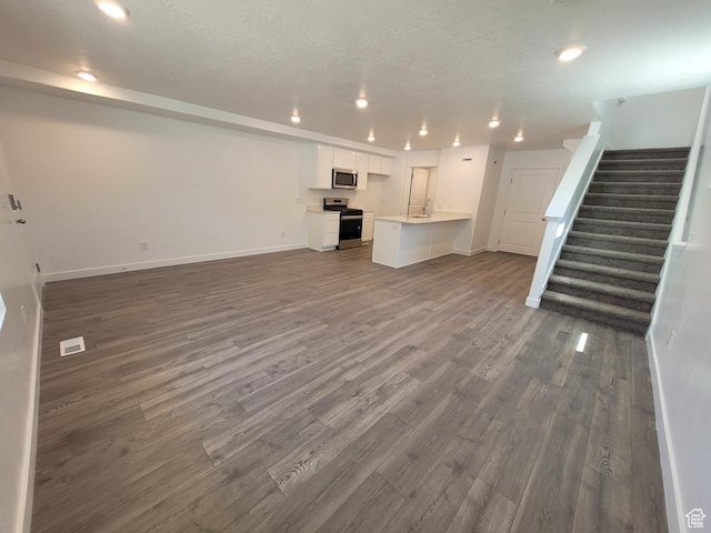 1596 S 3740 E Unit 1358, Spanish Fork, UT 84660 - unfurnished living room featuring dark wood finished floors, stairs, recessed lighting, and a textured ceiling