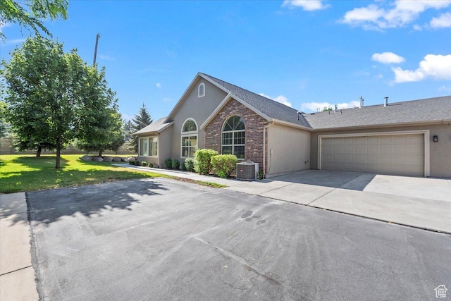 317 S 450 W Unit C, Springville, UT 84663 - view of front facade with driveway, a garage, stucco siding, a front yard, and a shingled roof