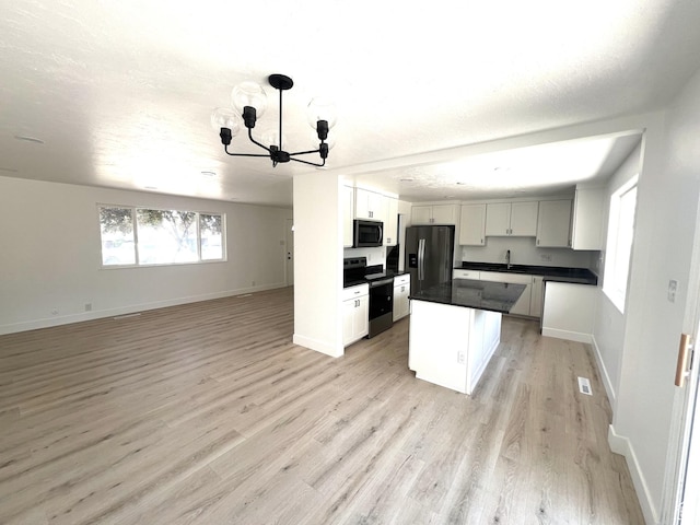 686 N Parkway Ave, Tooele, UT 84074 - kitchen featuring stainless steel electric range, fridge with ice dispenser, open floor plan, black microwave, and a chandelier