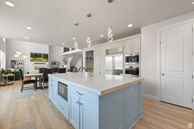 2430 N 325 E, Lehi, UT 84043 - kitchen featuring built in appliances, light wood finished floors, a kitchen island, hanging light fixtures, and recessed lighting