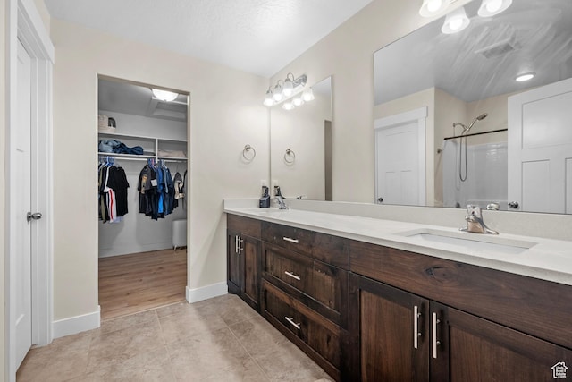 2722 E Iron Bark Aly, Eagle Mountain, UT 84005 - full bathroom with double vanity, a shower, a spacious closet, and tile patterned flooring