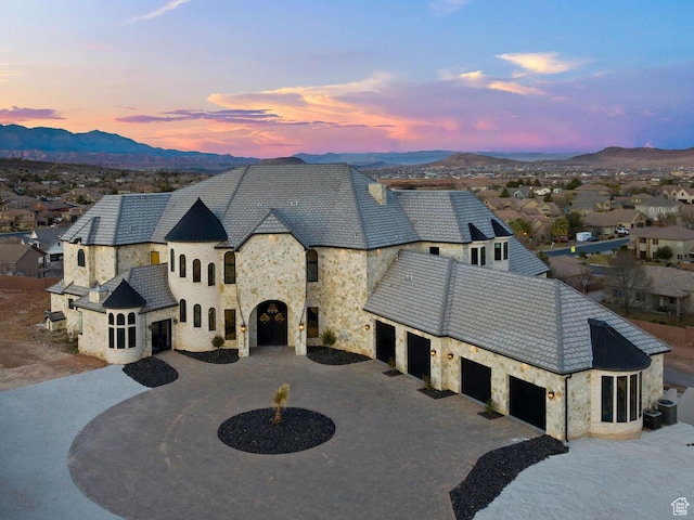 2836 S 2300th Cir E, St George, UT 84790 - view of front of house with stone siding, curved driveway, a mountain view, and an attached garage