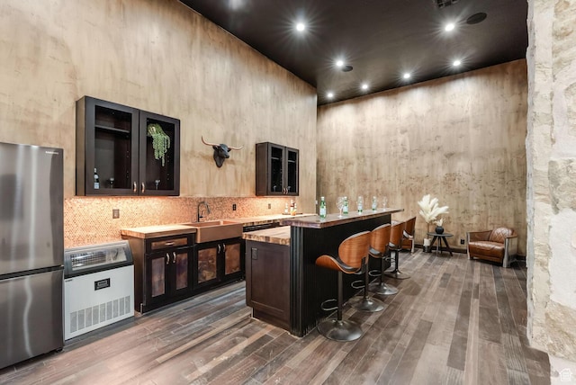 2836 S 2300th Cir E, St George, UT 84790 - bar area with freestanding refrigerator, heating unit, dark wood-type flooring, backsplash, and a towering ceiling