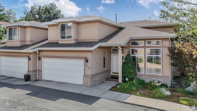 2262 E Emerald Hills Ct, Cottonwood Heights, UT 84121 - view of front facade with an attached garage, stucco siding, brick siding, a shingled roof, and driveway