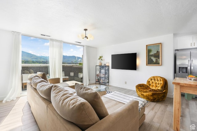 777 E S Temple S Unit 15E, Salt Lake City, UT 84102 - living room featuring light wood-style flooring, a textured ceiling, and expansive windows